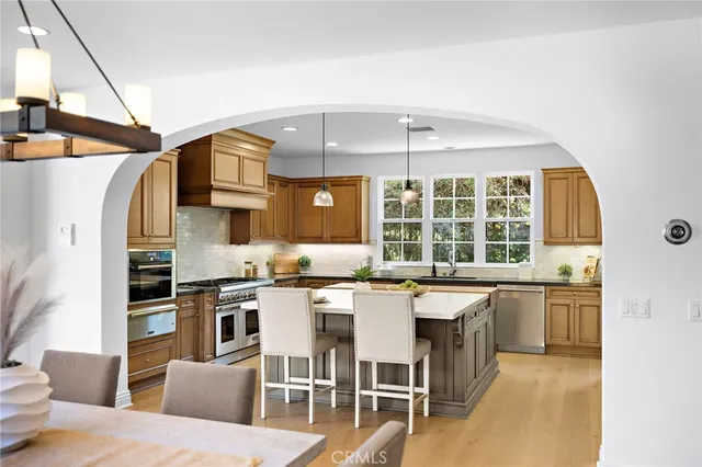 a kitchen that has a sink a stove and chairs