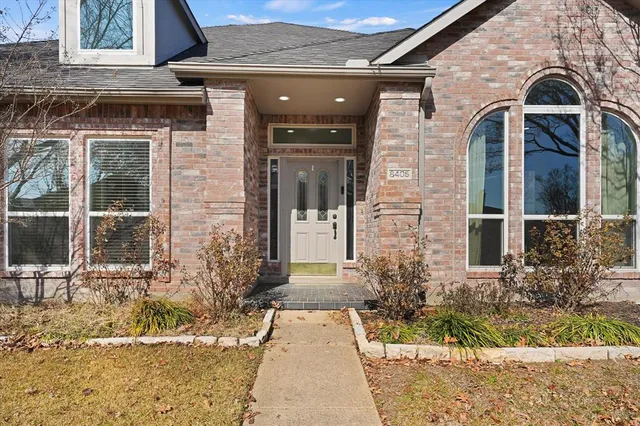 front view of a brick house with a small yard