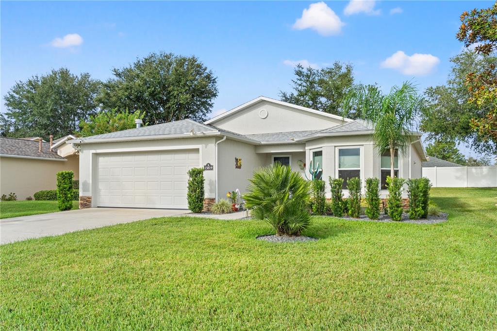15819 Southwest 13th Circle Ocala, FL 34473 - Photo 33 of 34 a front view of a house with a yard and garage