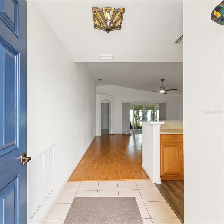 15819 Southwest 13th Circle Ocala, FL 34473 - Photo 5 of 34 a hallway with a dining table and a refrigerator