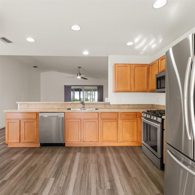 15819 Southwest 13th Circle Ocala, FL 34473 - Photo 6 of 34 a kitchen with granite countertop a stove top oven sink and cabinets