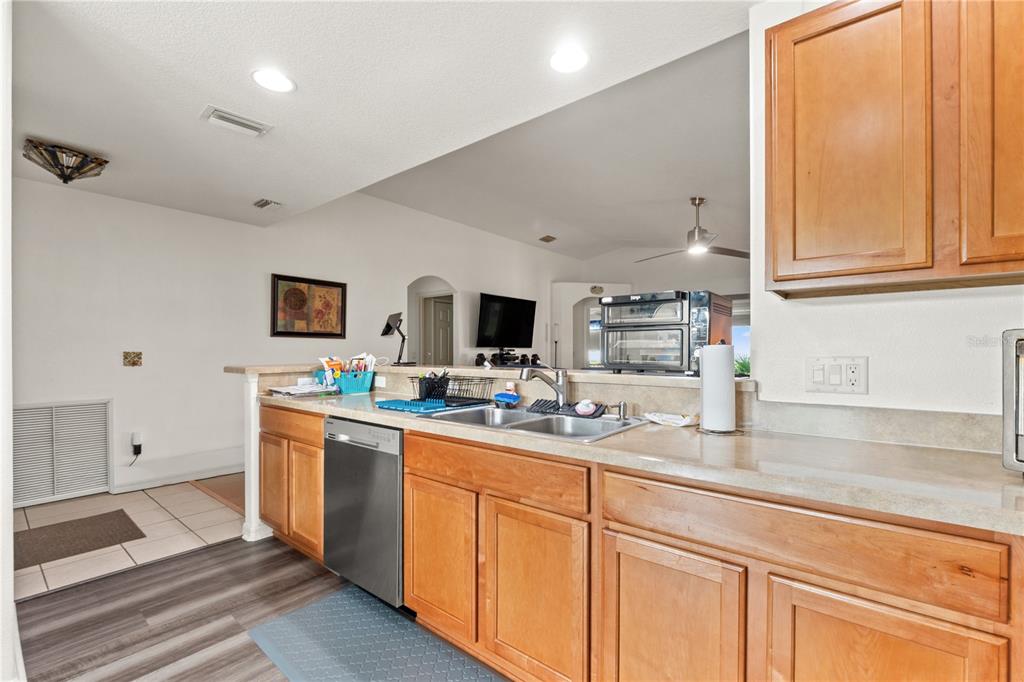 15819 Southwest 13th Circle Ocala, FL 34473 - Photo 7 of 34 a kitchen with stainless steel appliances granite countertop a sink and cabinets with wooden floor