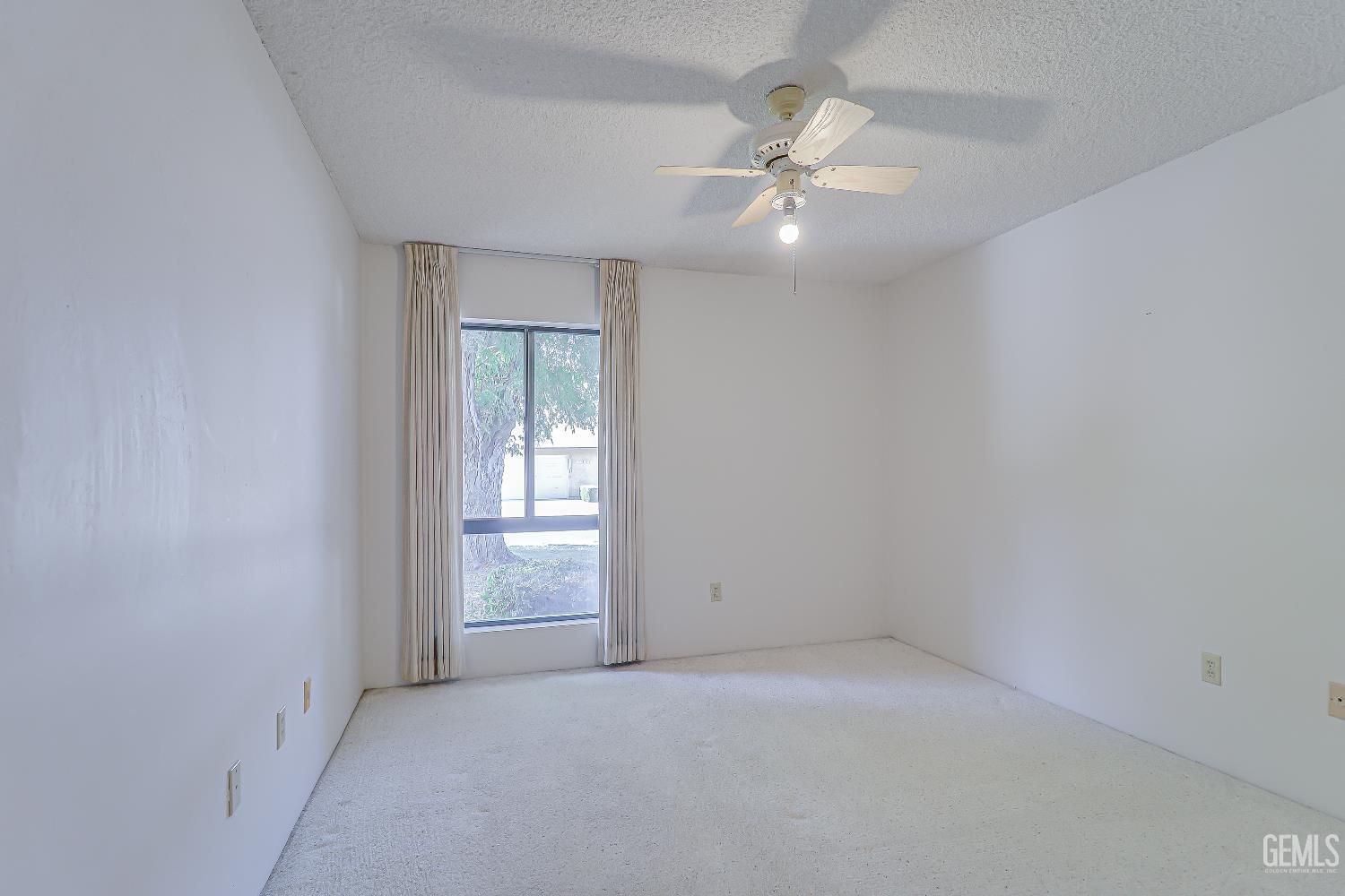 Undisclosed Address Bakersfield, CA 93309 - Photo 14 of 37 an empty room with a chandelier fan and windows
