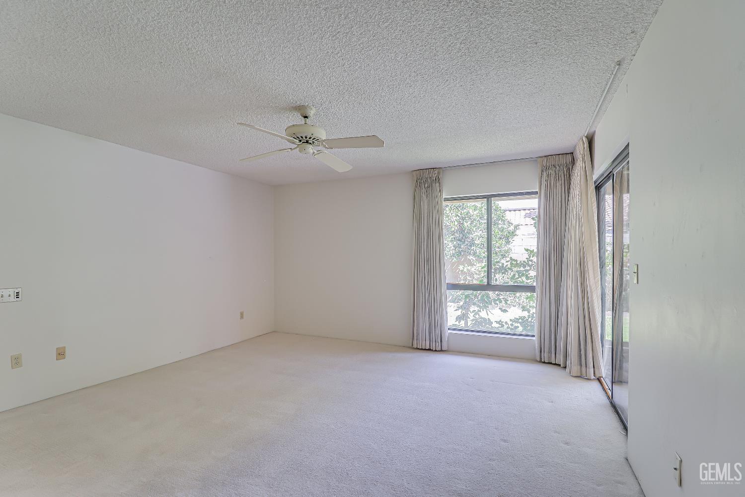 Undisclosed Address Bakersfield, CA 93309 - Photo 17 of 37 an empty room with chandelier fan and windows