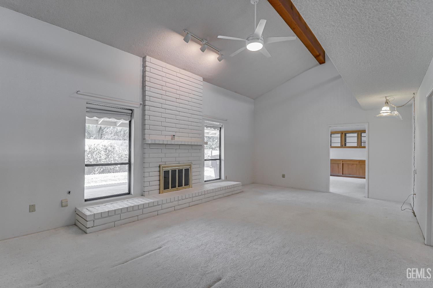 Undisclosed Address Bakersfield, CA 93309 - Photo 8 of 37 an empty room with windows and fireplace