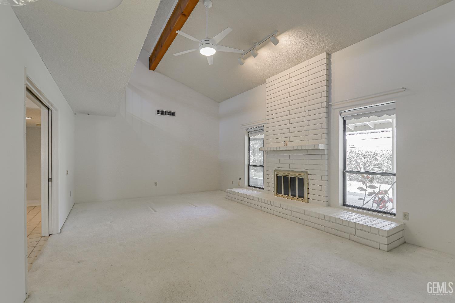 Undisclosed Address Bakersfield, CA 93309 - Photo 10 of 37 an empty room with windows and fireplace