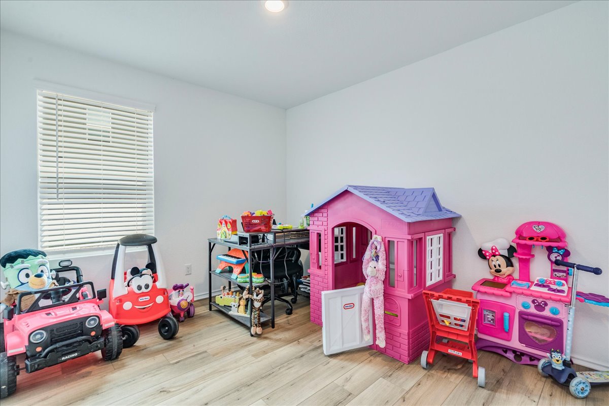 389 Salt Springs Road Kyle, TX 78640 - Photo 18 of 30 A cheerful play area featuring light hardwood flooring and a brightly lit window.