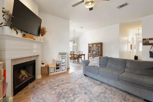 a living room with furniture a flat screen tv and a fireplace