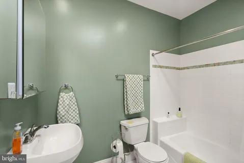 a white toilet sitting next to a bathroom sink and shower