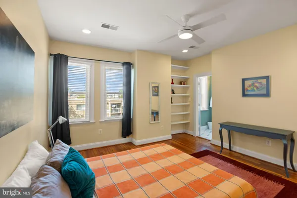 a spacious bedroom with a large bed and a chandelier