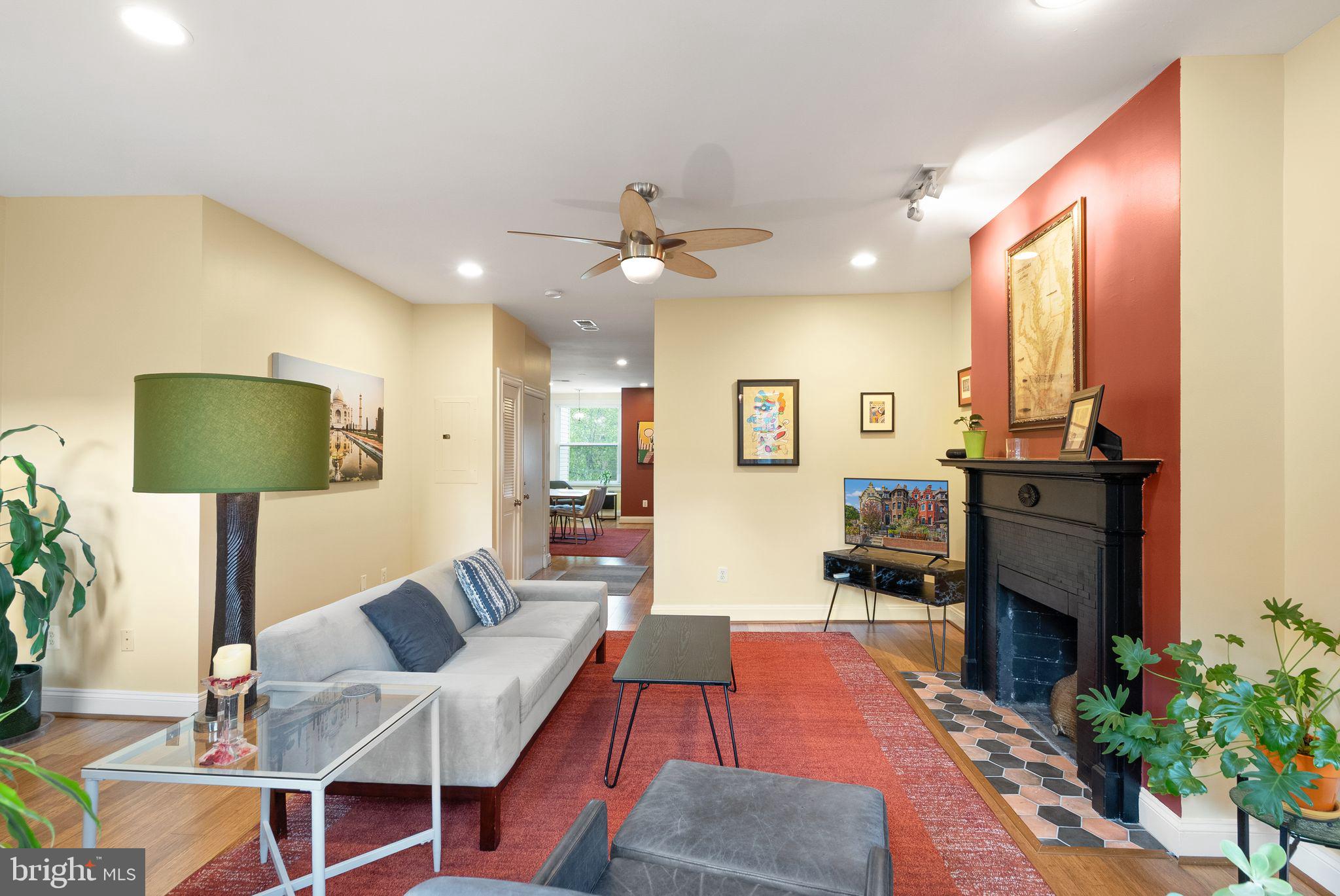 1335 Harvard Street Northwest, Unit PH2 Washington, DC 20009 - Photo 5 of 34 a living room with furniture a chandelier and a flat screen tv