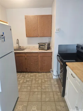 a kitchen with a sink a stove top oven and cabinets