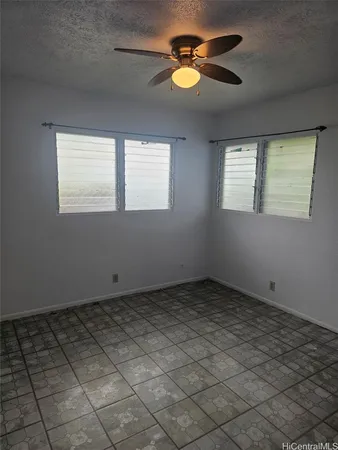 an empty room with windows and fan