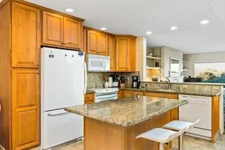 a kitchen with stainless steel appliances granite countertop a refrigerator and a stove top oven