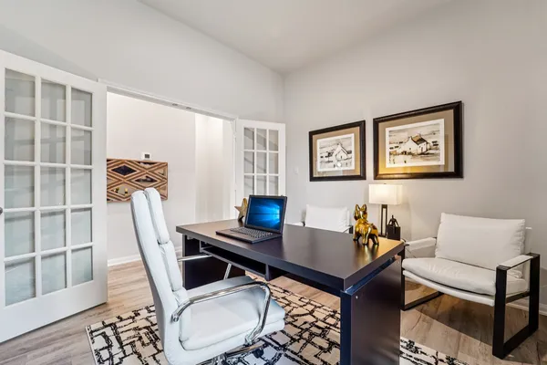 a living room with furniture a desk and chair with wooden floor