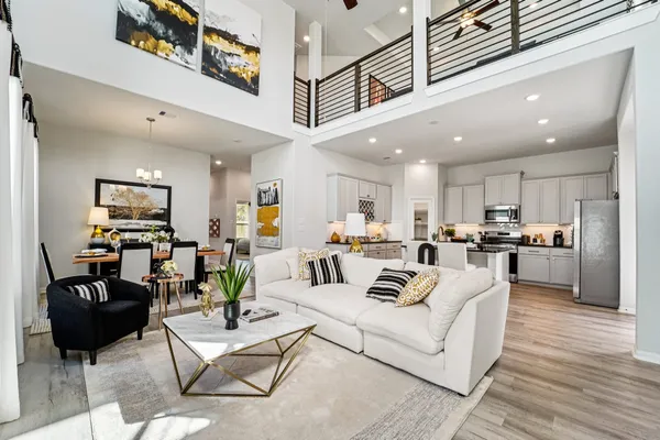 a living room with furniture kitchen view and a wooden floor