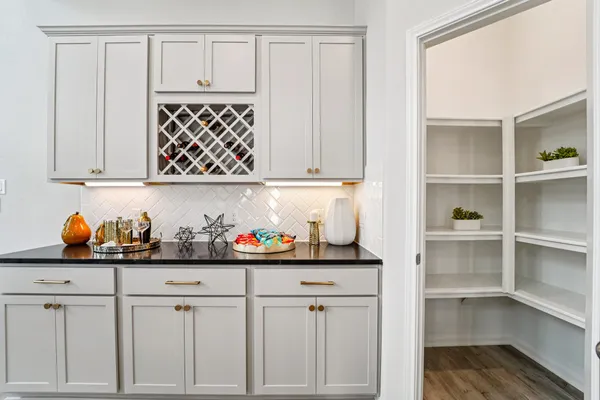 a kitchen with white cabinets and window