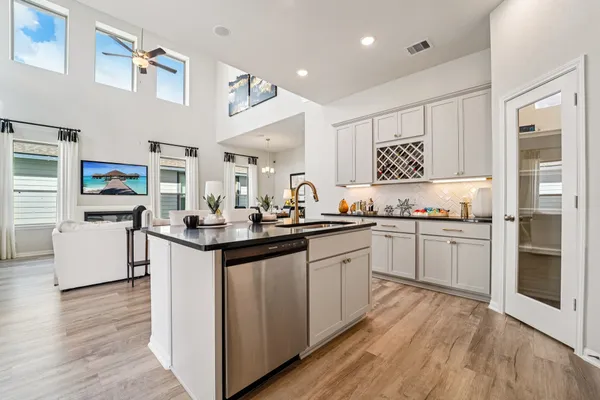 a kitchen with granite countertop a sink cabinets and stainless steel appliances
