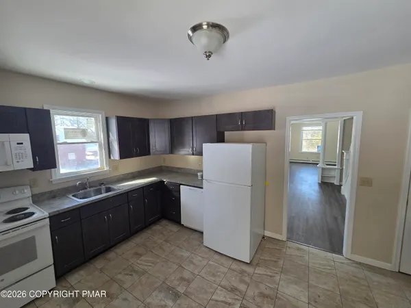 a kitchen with refrigerator and cabinets