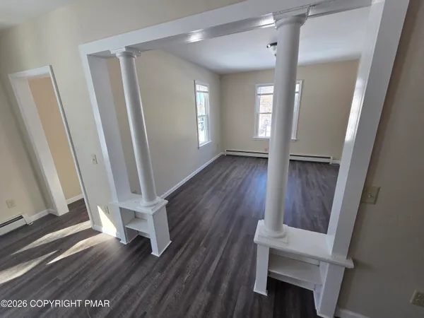 a view of a hallway with wooden floor and staircase