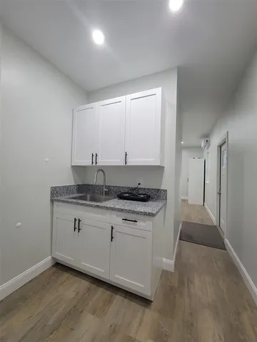 a kitchen with granite countertop a sink and a stove top oven