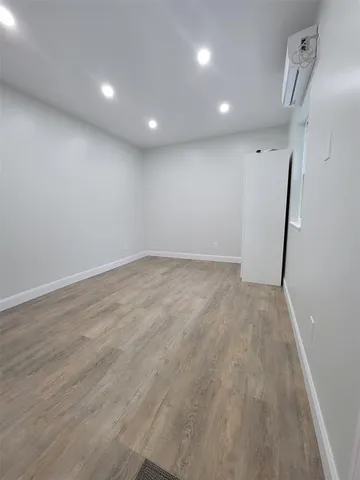 an empty room with wooden floor and entrance