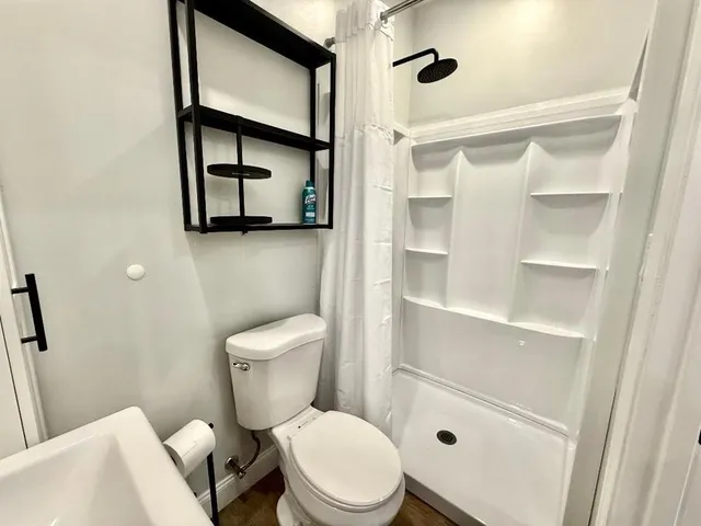 a white toilet sitting next to a bathroom sink and a mirror