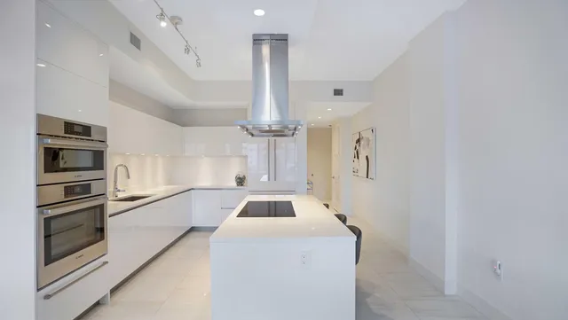 a kitchen with stainless steel appliances kitchen island a table and chair in it