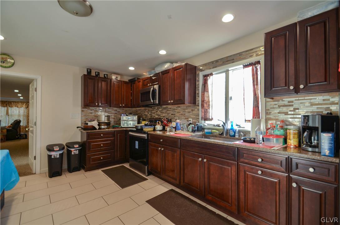 101 Coolbaugh Road East Stroudsburg, PA 18302 - Photo 5 of 24 a kitchen with stainless steel appliances granite countertop a refrigerator a sink dishwasher and wooden cabinets with wooden floor