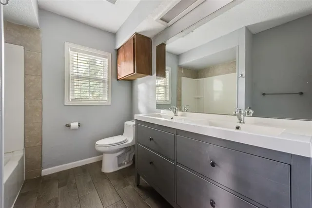 a bathroom with a double vanity sink toilet and a mirror