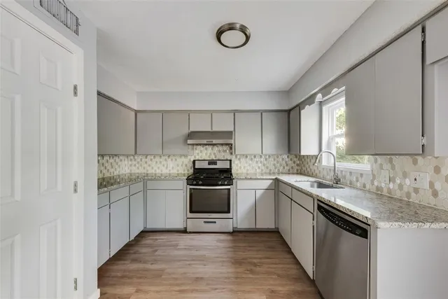a kitchen with stainless steel appliances granite countertop a stove and a sink