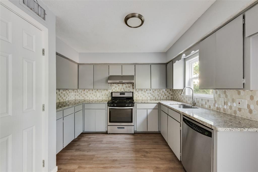 415 Pierce Street Denton, TX 76201 - Photo 5 of 14 a kitchen with stainless steel appliances granite countertop a stove and a sink