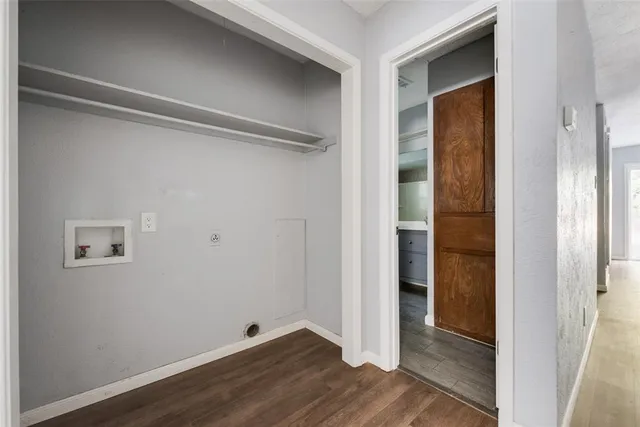 a view of an empty room with wooden floor and closet