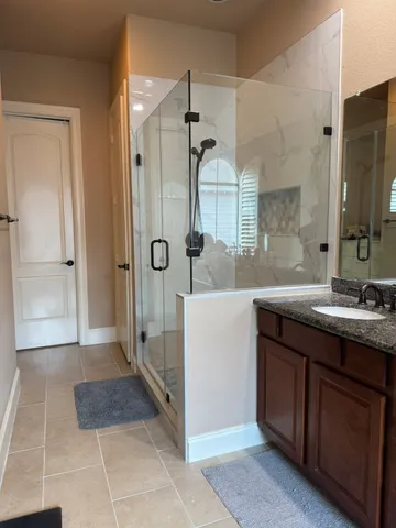 a bathroom with a granite countertop sink a toilet a mirror and shower