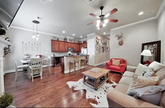a living room with furniture kitchen view and a chandelier