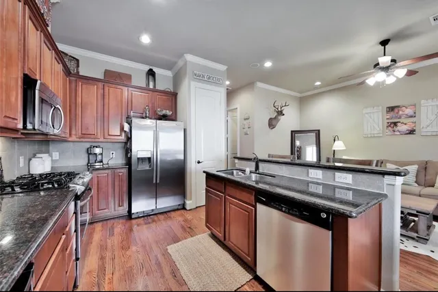 a kitchen with stainless steel appliances granite countertop a sink stove and refrigerator