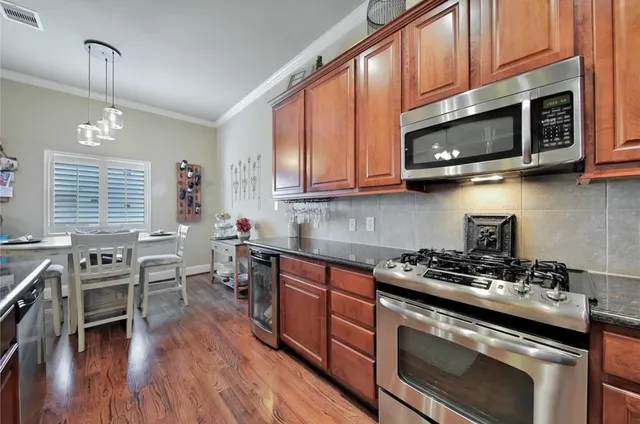 a kitchen with stainless steel appliances a stove microwave and cabinets