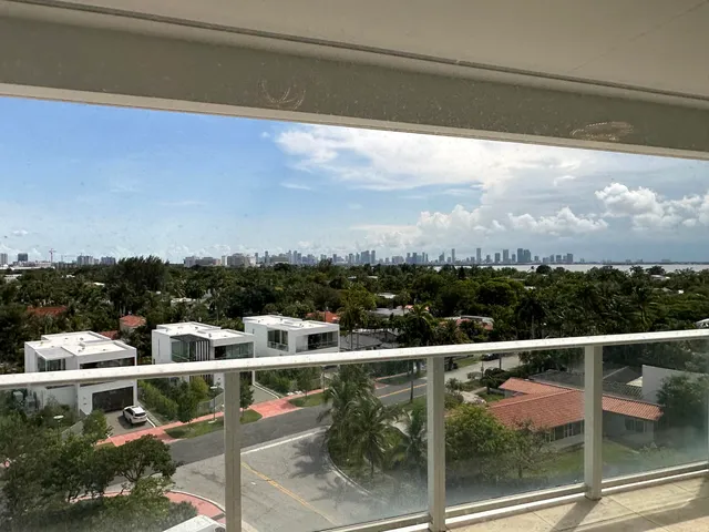 a back view of a room that has a bed and a large window