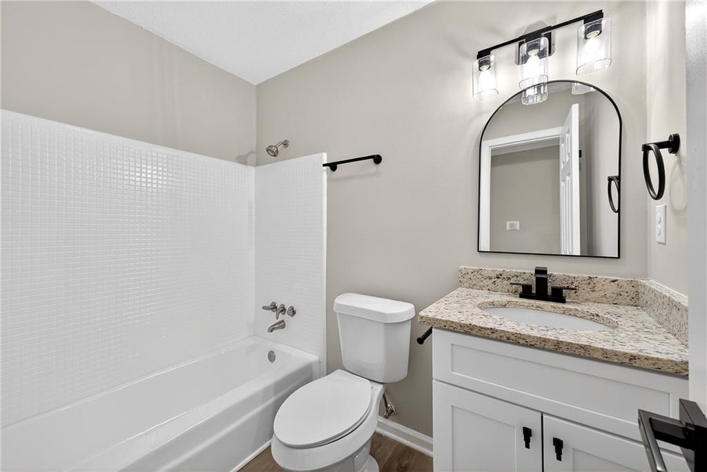187 Old Timber Road Lawrenceville, GA 30046 - Photo 22 of 32 a bathroom with a granite countertop toilet sink and mirror