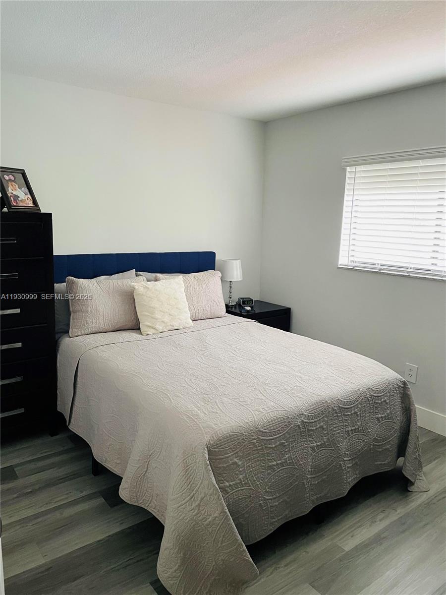 11527 Southwest 90th Terrace Miami, FL 33176 - Photo 14 of 20 a bedroom with a bed and wooden floor