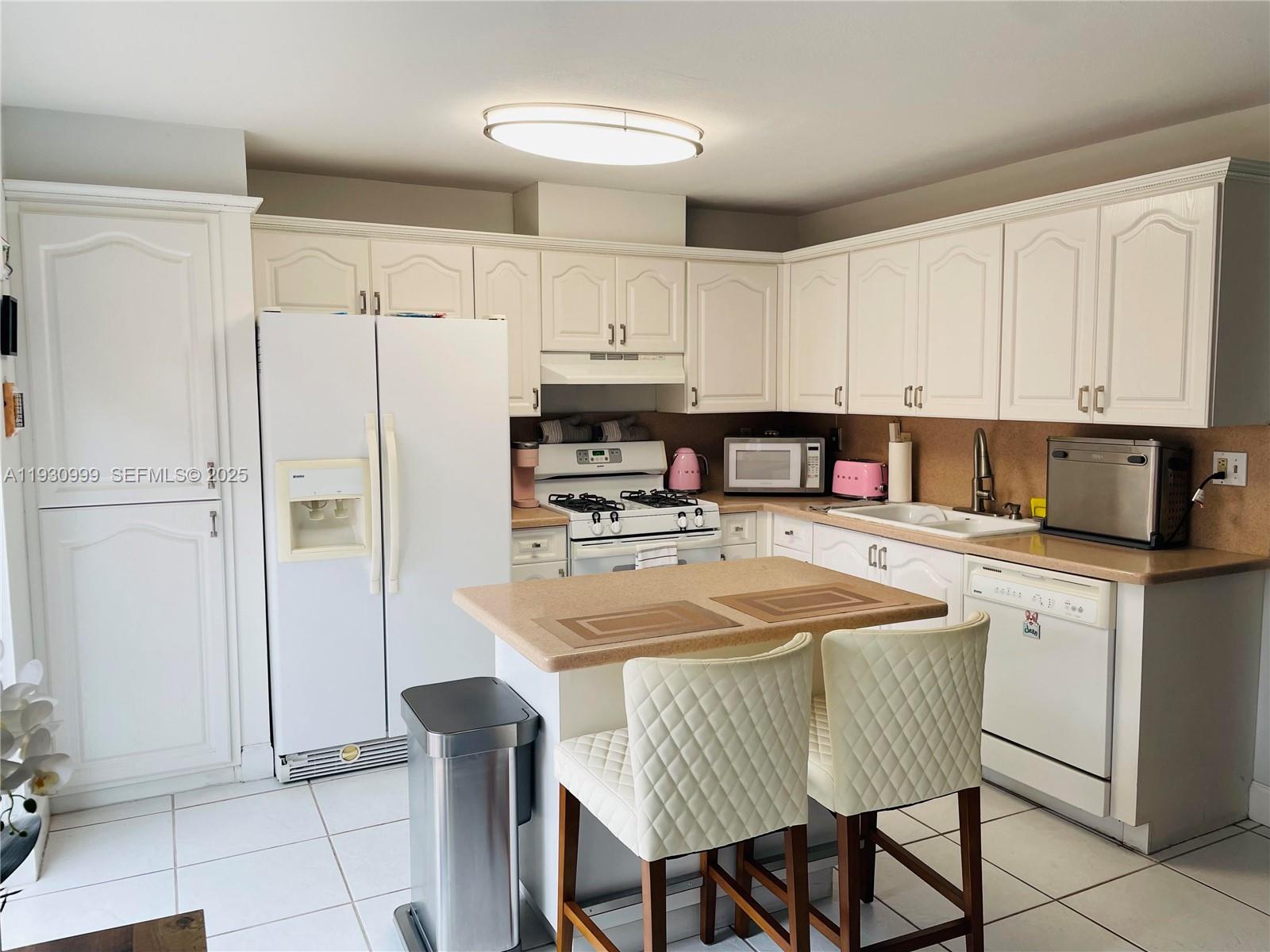 11527 Southwest 90th Terrace Miami, FL 33176 - Photo 7 of 20 a kitchen with stainless steel appliances granite countertop a refrigerator a sink a stove a dining table and chairs