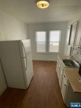 a kitchen with sink a refrigerator and window