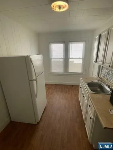 a kitchen with sink a refrigerator and window