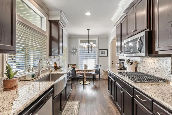 a kitchen with granite countertop a sink stove and cabinets