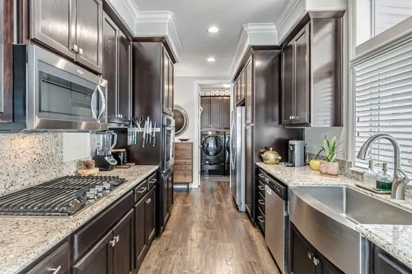 a kitchen with stainless steel appliances granite countertop sink stove refrigerator and cabinets