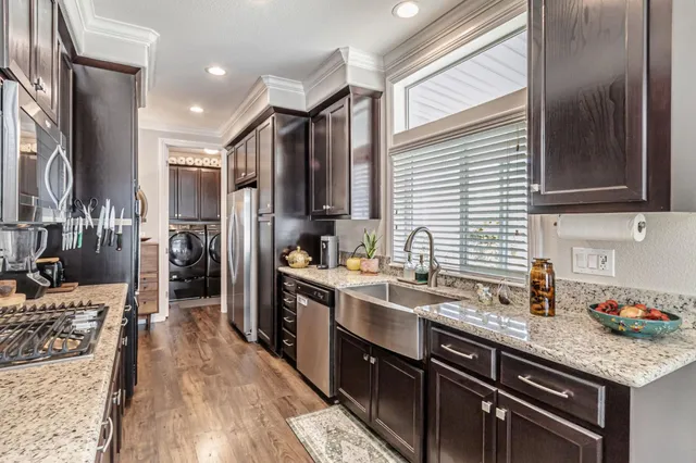 a kitchen with stainless steel appliances granite countertop a refrigerator and a sink