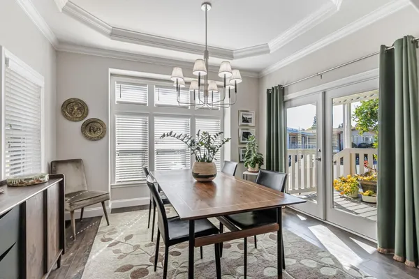 a dining room with wooden floor and large windows