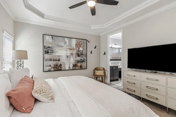 a bedroom with a large bed and a chandelier