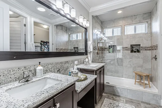 a bathroom with a granite countertop sink a toilet a mirror and shower