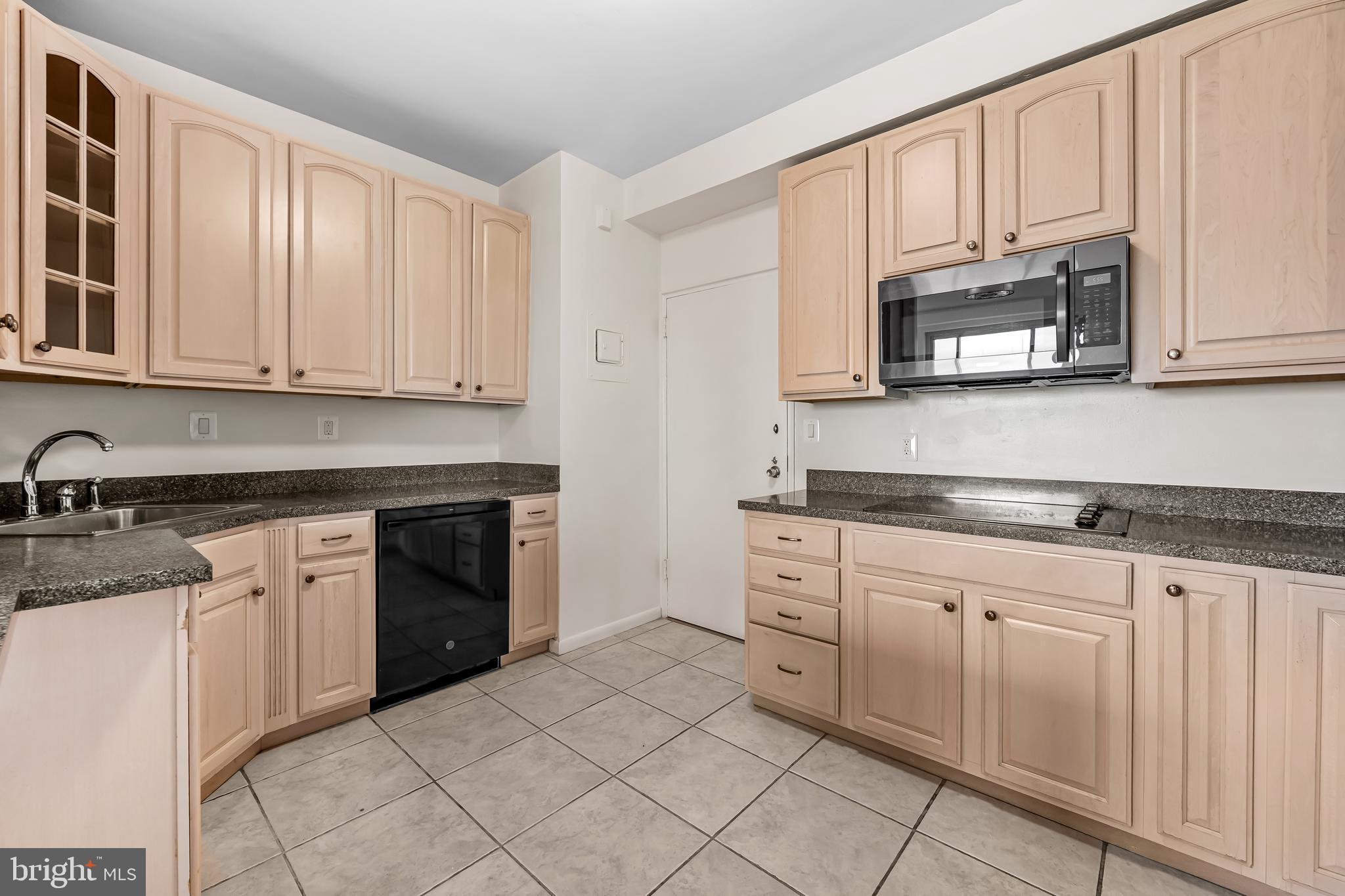 11 Slade Avenue, Unit 911 Baltimore, MD 21208 - Photo 18 of 32 a kitchen with granite countertop white cabinets stainless steel appliances and a sink